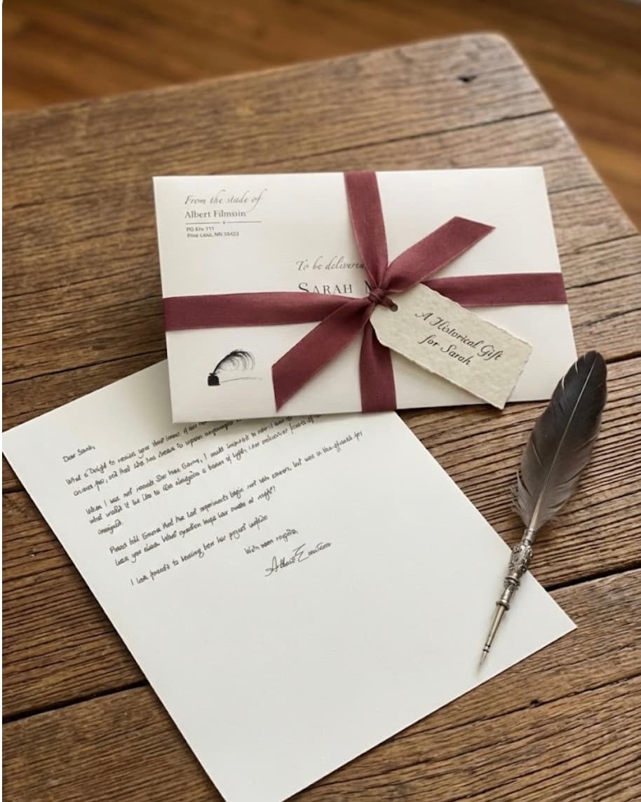 A handwritten letter from a historical pen pal, gift-wrapped with ribbon and a personalized tag