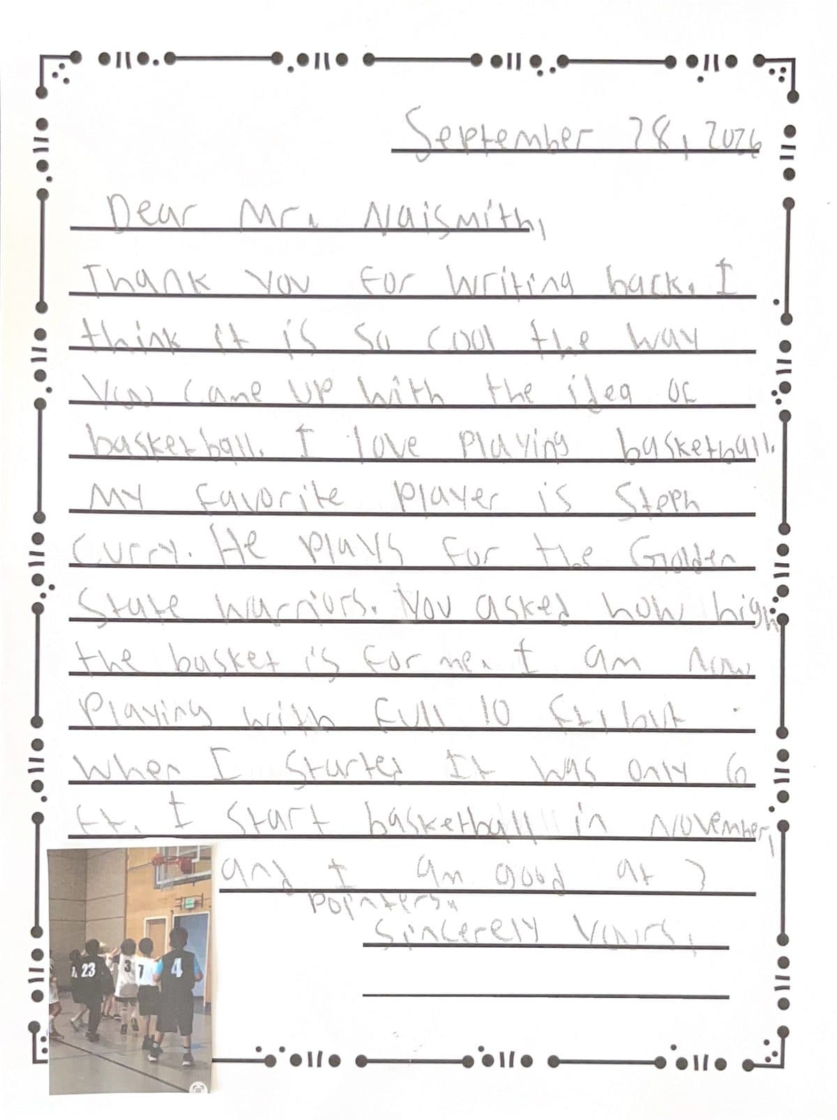 A child's letter to James Naismith in pencil on a page with a dotted border, with a small photo of a youth basketball game glued to the bottom corner